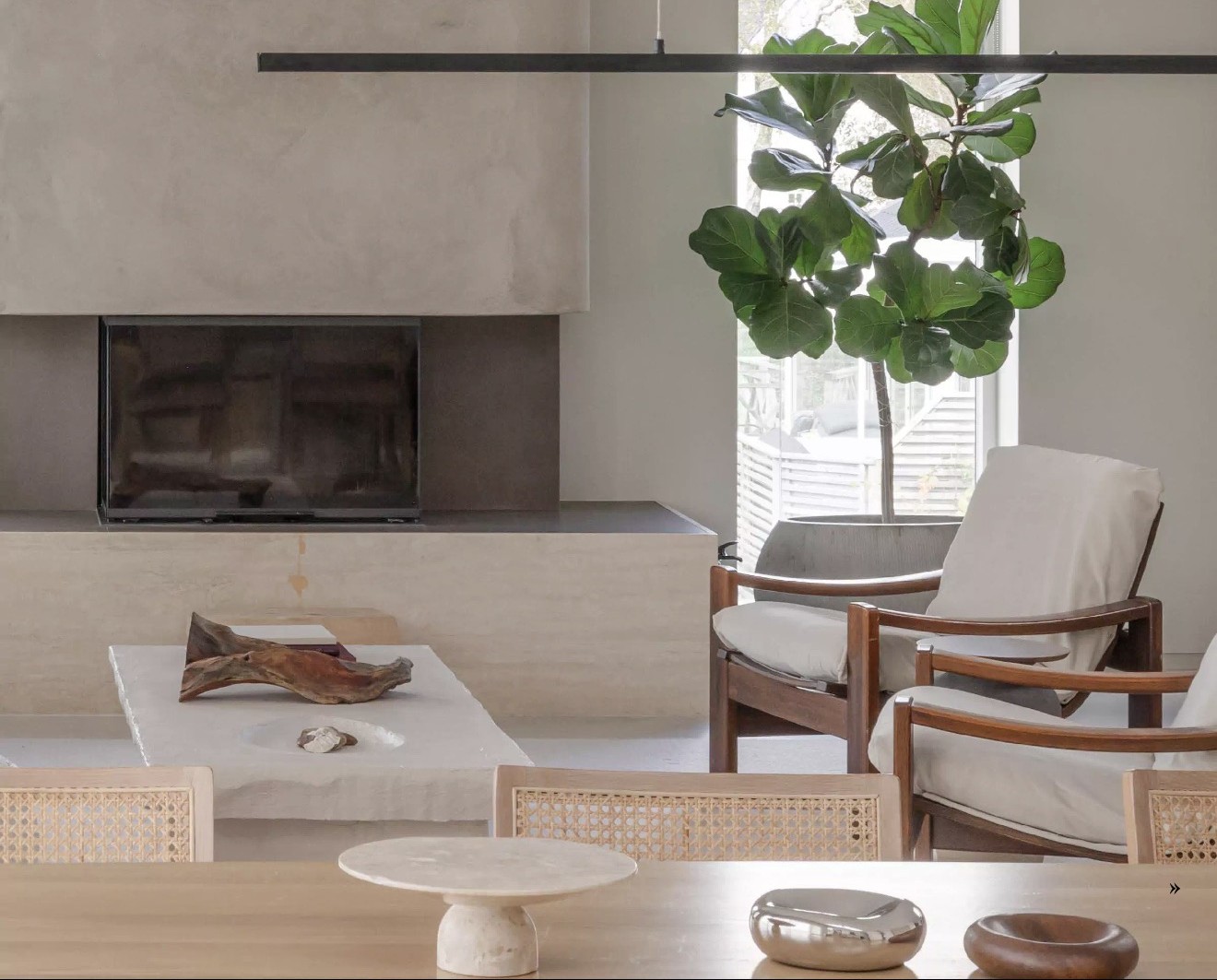 Fireplace wall in raw concrete with travertine hearth